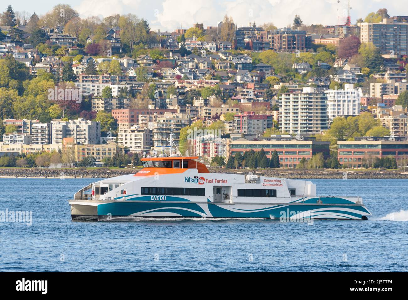 Seattle - 22. April 2022; Kitsap Fast Ferries Katamaran Enetai verlässt Seattle mit Service über die Elliott Bay mit Hang in Queen Anne dahinter Stockfoto