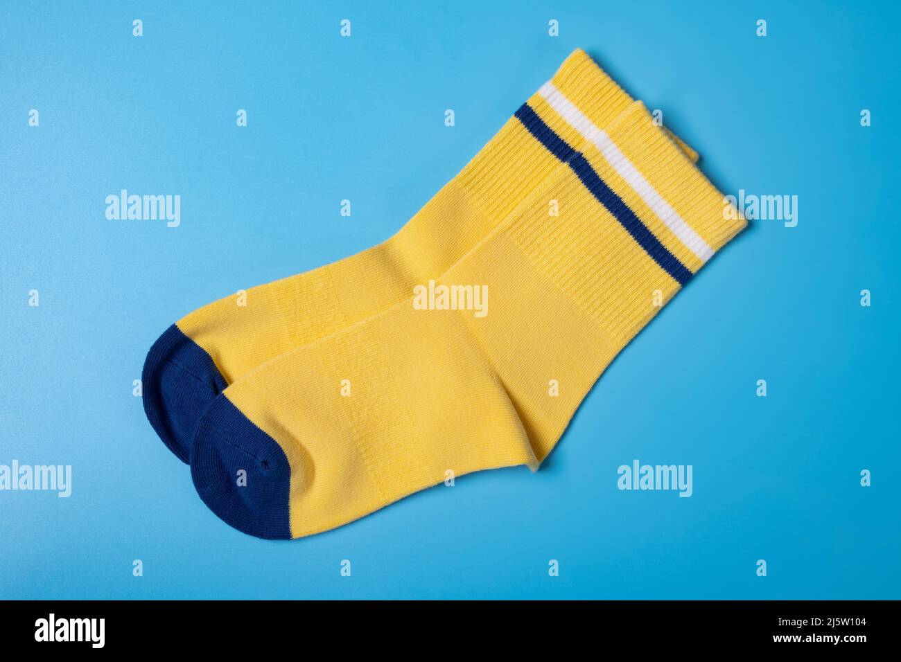 Paar gelbe Socken für Jungen auf blauem Hintergrund Stockfoto