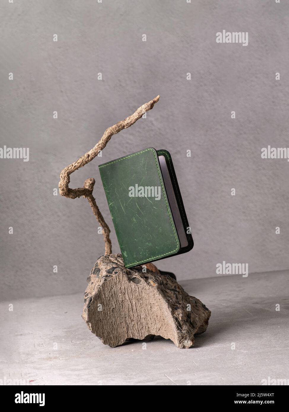 Grüner Ledereinband auf grauem Stein als Podium Stockfoto