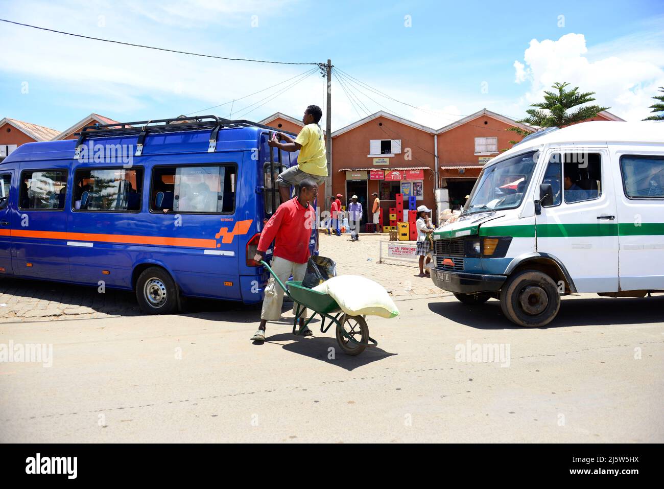 Ein madagassischer Mann, der in der Ambohimanga-Region im Zentrum Madagaskars einen doppelrädrigen Schubkarrenwagen schiebt. Stockfoto