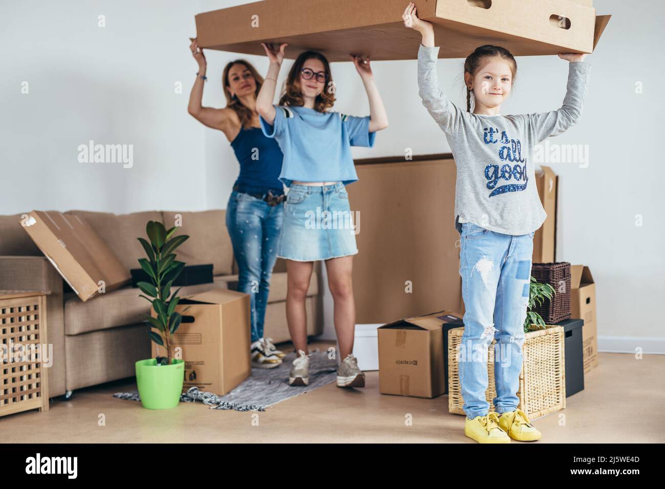 Familie packt Pappkartons in neuem Zuhause aus. Stockfoto