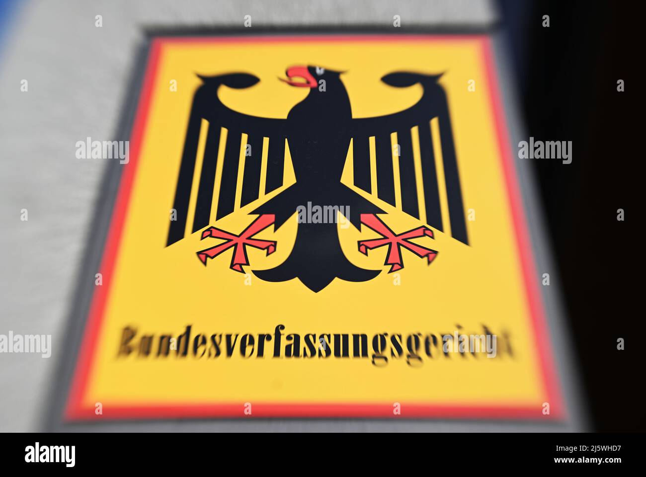 Karlsruhe, Deutschland. 26. April 2022. Außenaufnahme des Bundesverfassungsgerichts mit einem Schild mit dem Bundesadler und dem Wort Bundesverfassungsgericht (Aufnahme mit Lensbaby-Linse). Der erste Senat will am 26.04.2022 das Urteil zum bayerischen Verfassungsschutzgesetz bekannt geben. Quelle: Uli Deck/dpa/Alamy Live News Stockfoto