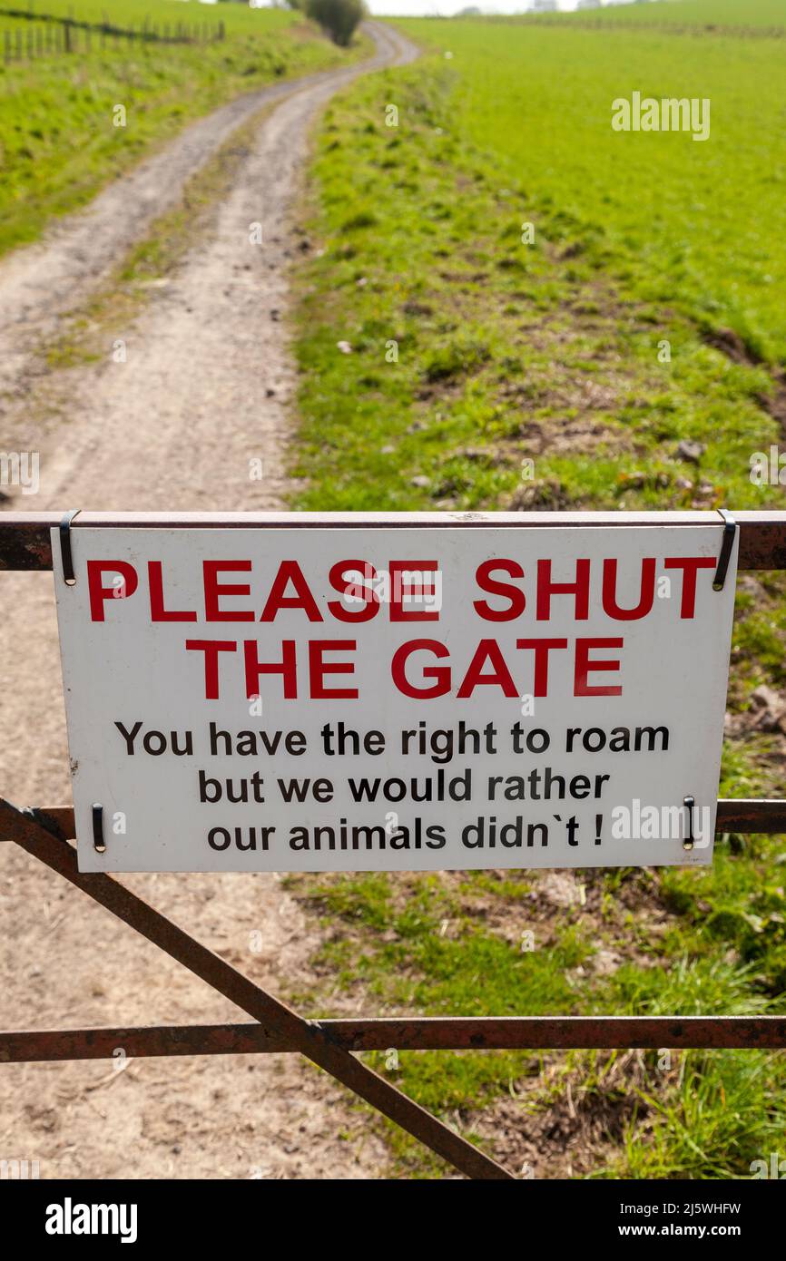 Ein Schild an einem Bauerntor: „Bitte schließt das Tor zu, Ihr habt das Recht zu durchstreifen, aber wir würden es lieber nicht mit unseren Tieren tun!“ Stockfoto