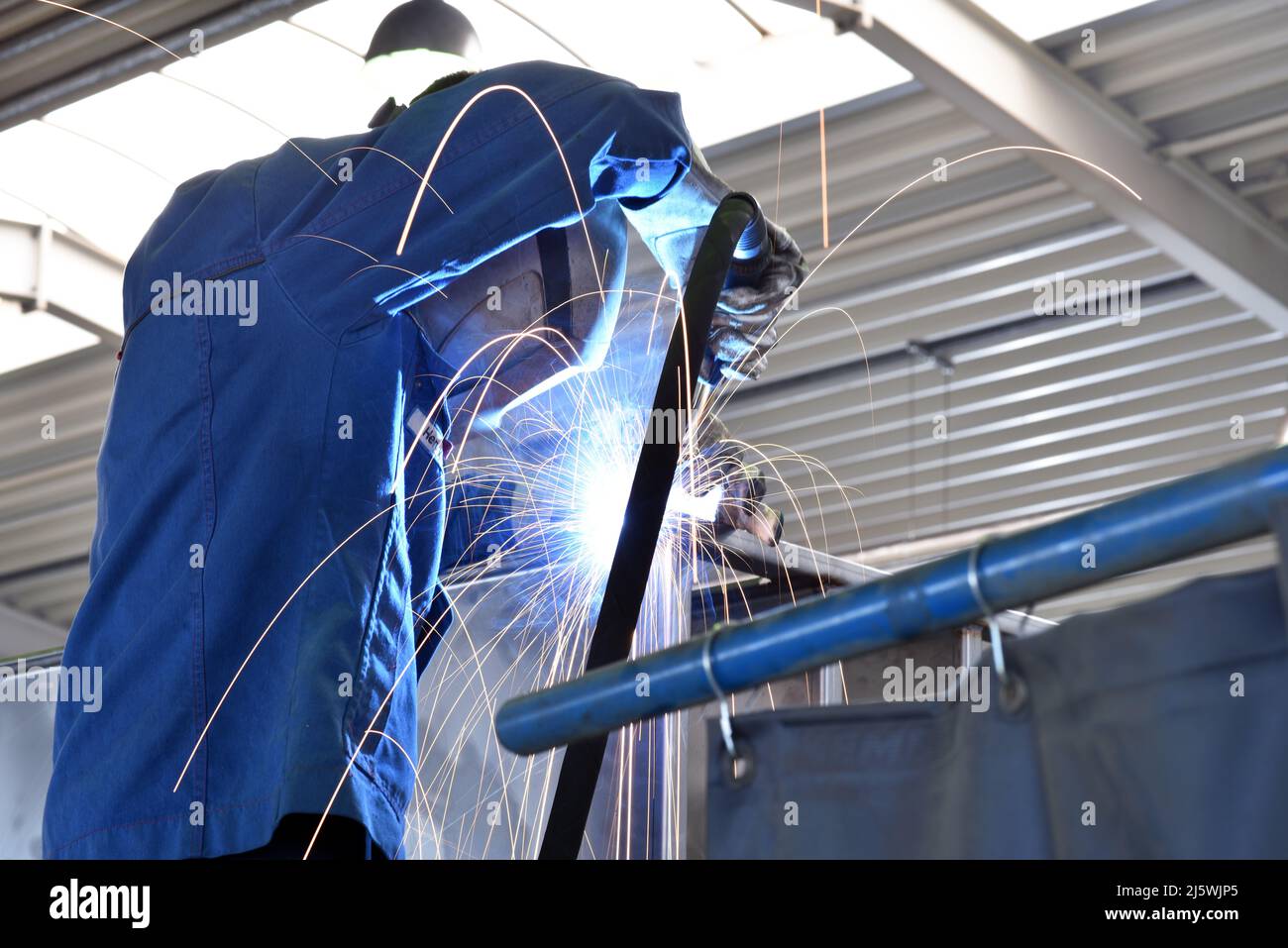 Schweißer bei der Arbeit in einem Stahlbauunternehmen - Arbeits- und Schutzkleidung Stockfoto