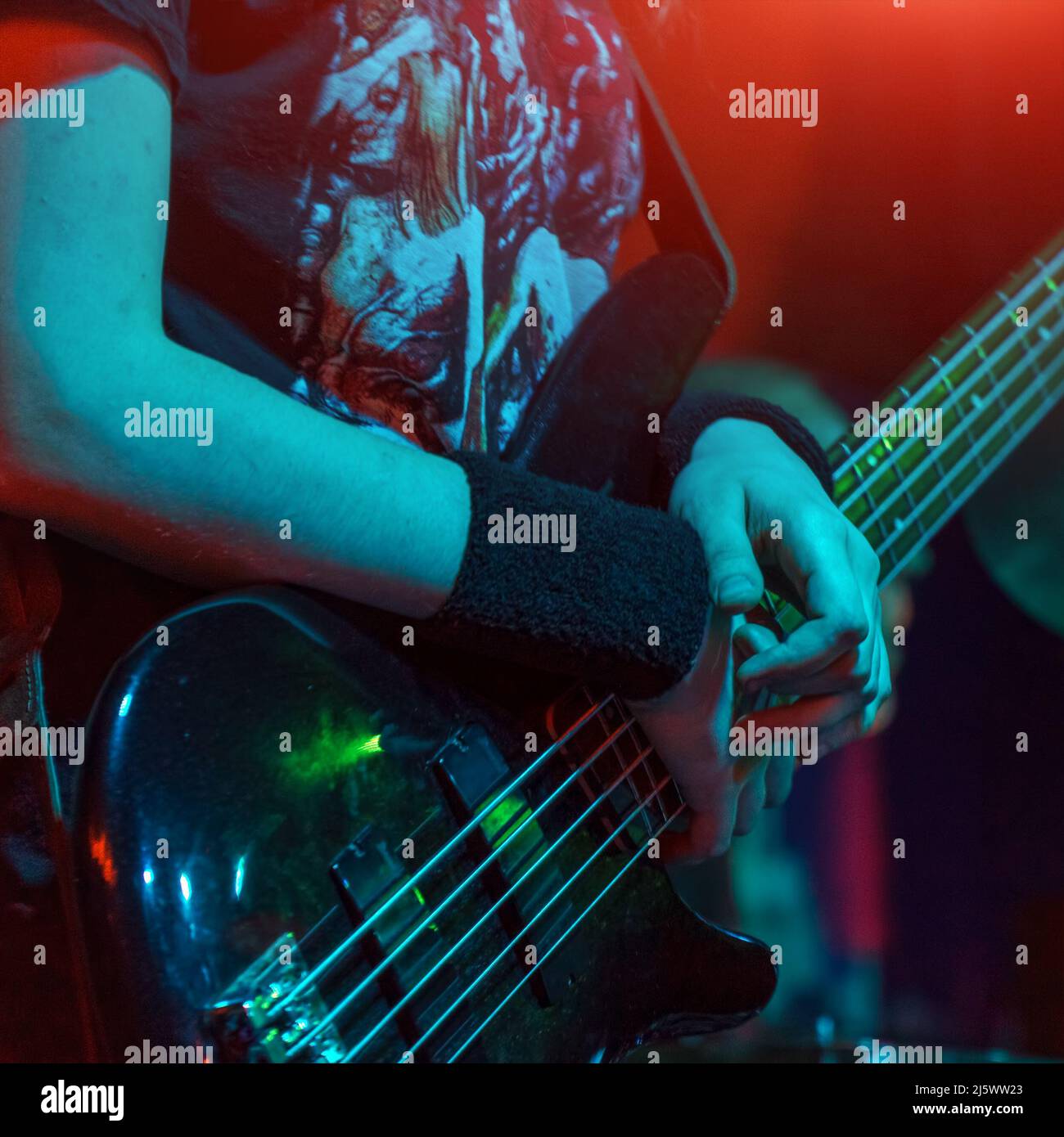 Bass Gitarristen auf der Bühne spielte Bass Gitarre close-up. Soft Focus Stockfoto