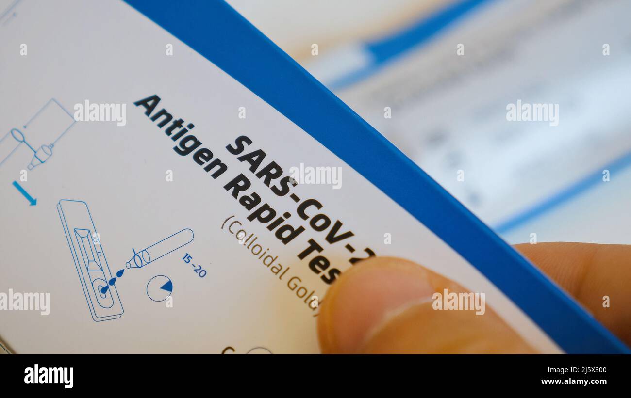 Nahaufnahme des Menschen untersucht Box mit SARS-Cov-2 Antigen Schnelltest mit Anweisung Stockfoto