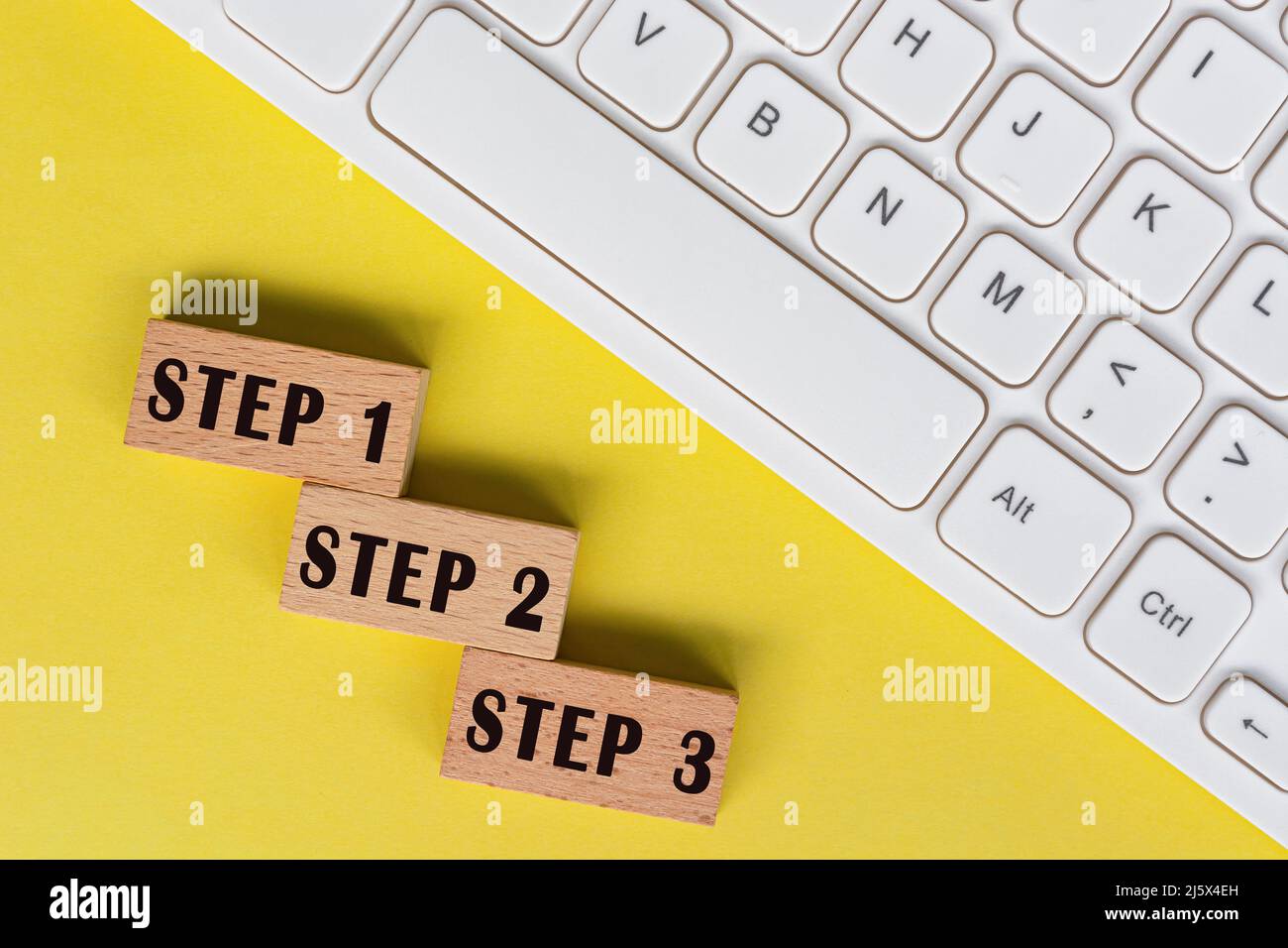 Schritt 1, 2 und 3 Text auf Holzblöcken mit Tastatur. Stockfoto