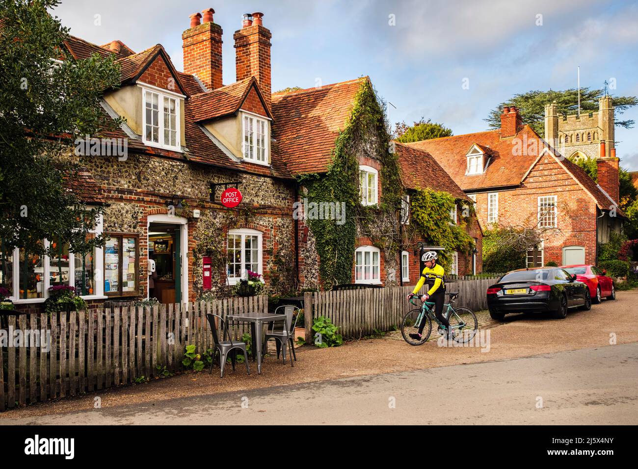 Ein Radfahrer vor dem Postamt und einkaufen im historischen malerischen Dorf Chilterns in Hambleden, Buckinghamshire, England, Großbritannien Stockfoto