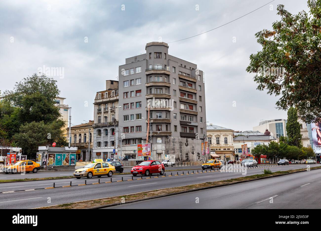 Hauptstraße und karge Architektur Apartmentblock in der Innenstadt von Bukarest, Hauptstadt von Rumänien, Mitteleuropa Stockfoto