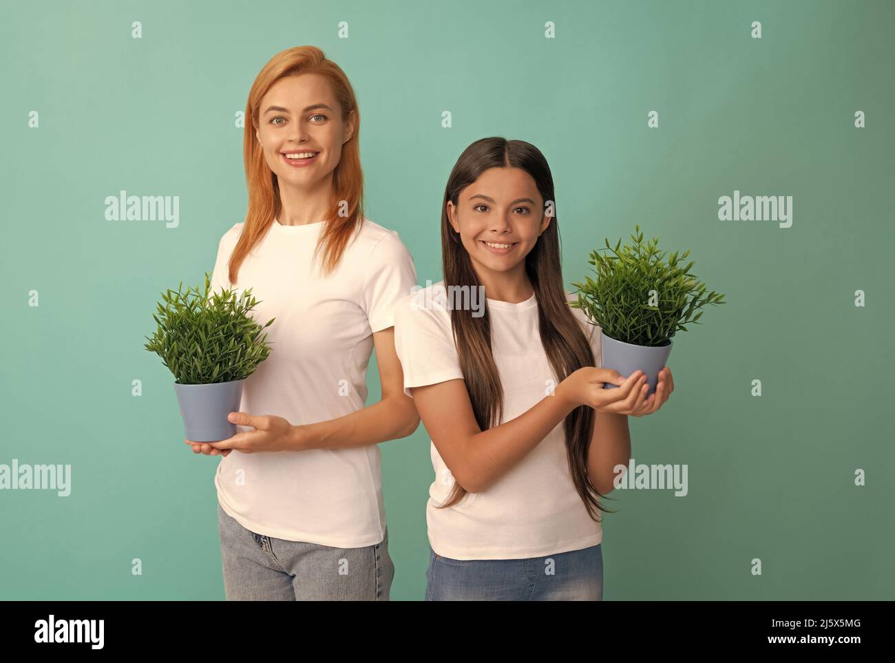 Förderung und Akzeptanz. Glücklich adoptierte Kind und Mutter halten Zimmerpflanzen. Pflegefamilie. Förderung Stockfoto