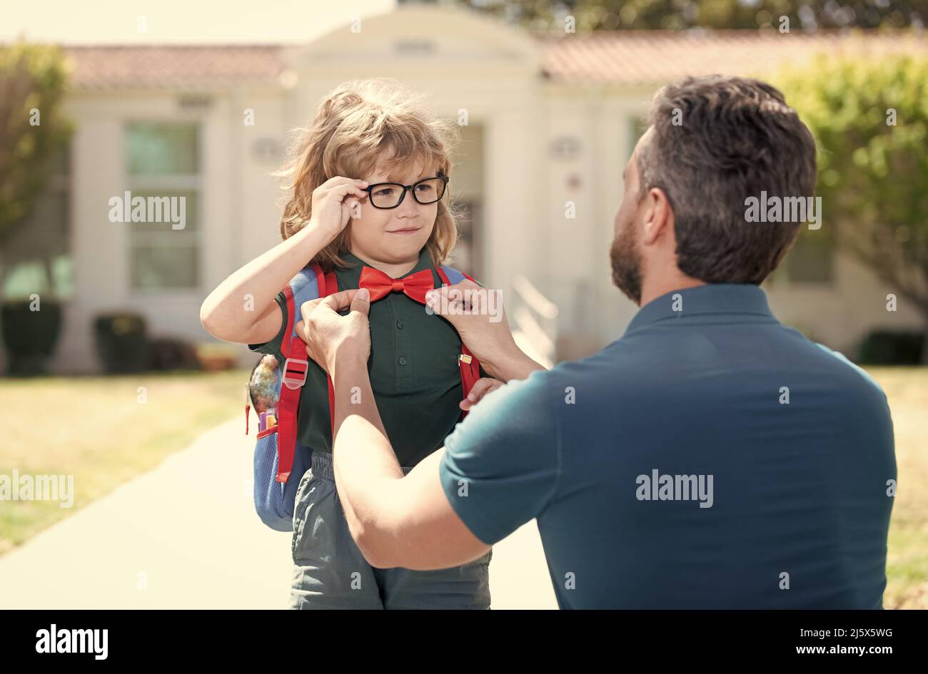 Nerd in Brille und Fliege mit Lehrer außerhalb der Schule, Bildung Stockfoto