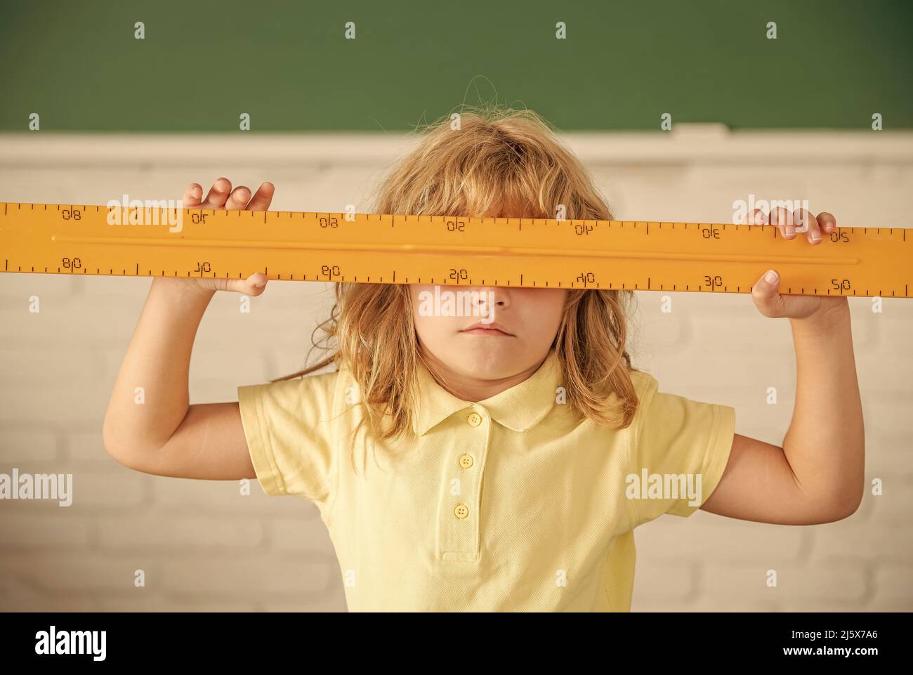 Kind Junge in der Schule hält Mathematik Lineal Werkzeug, Schule Stockfoto