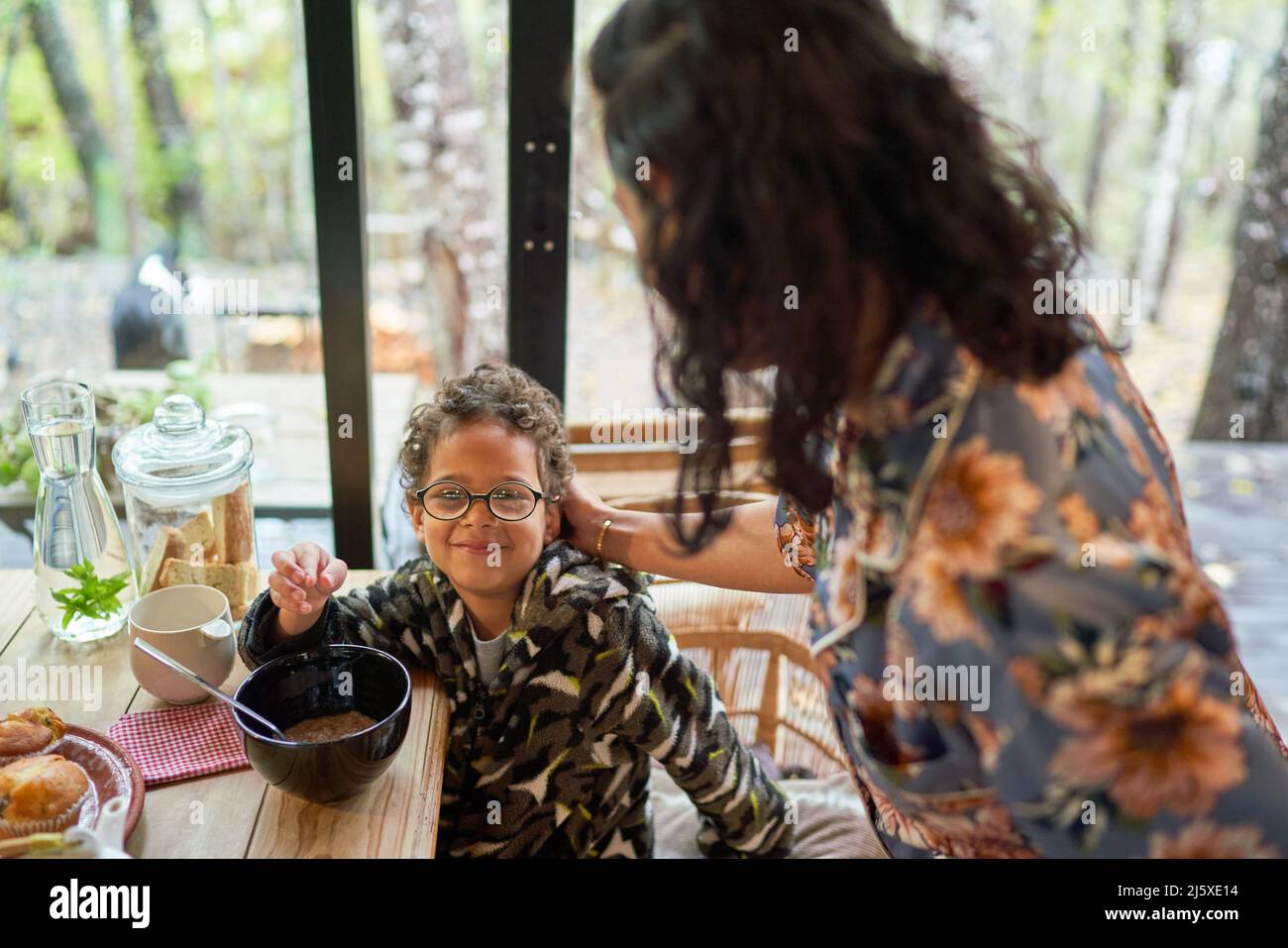 Portrait glücklicher Junge beim Essen am Esstisch Stockfoto