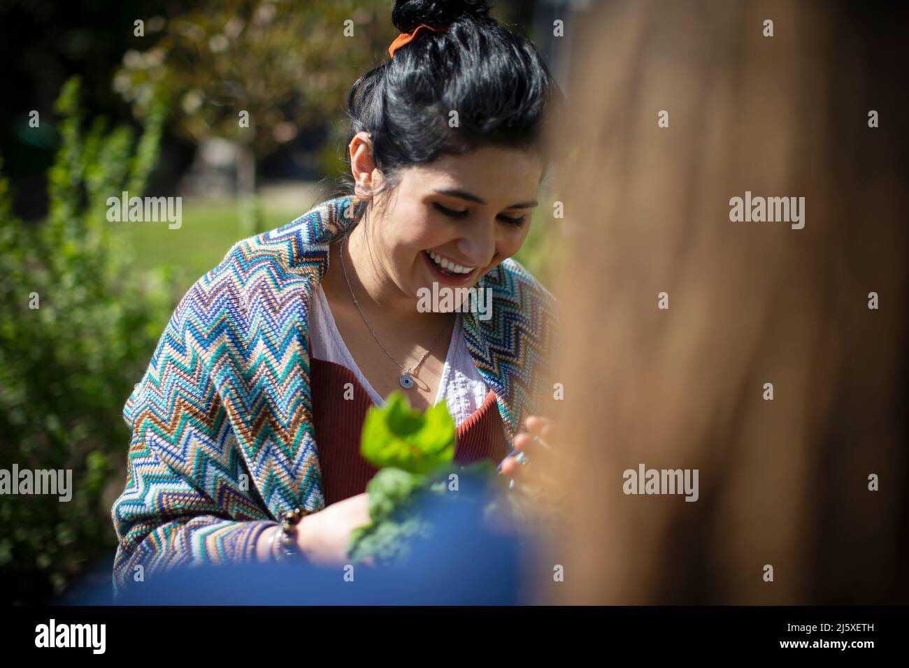 Glückliche junge Frau im sonnigen Garten Stockfoto