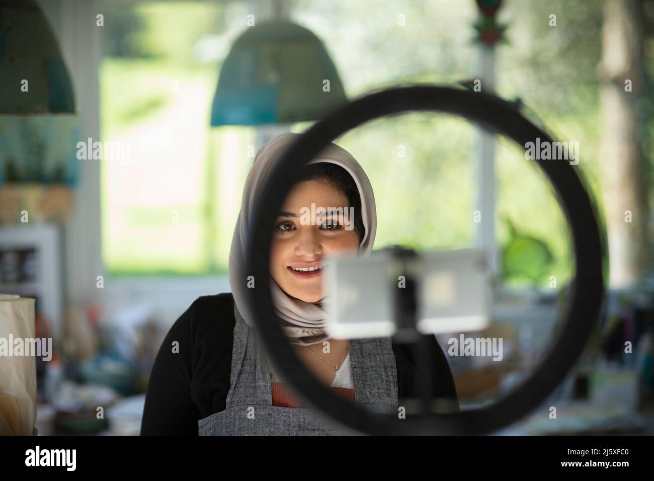 Junge weibliche Influencerin bei Hijab-Aufnahmen im Künstlerstudio Stockfoto
