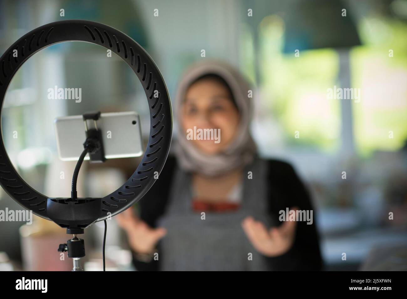 Junge muslimische Influencerin vloggt mit Kamera-Handy Stockfoto
