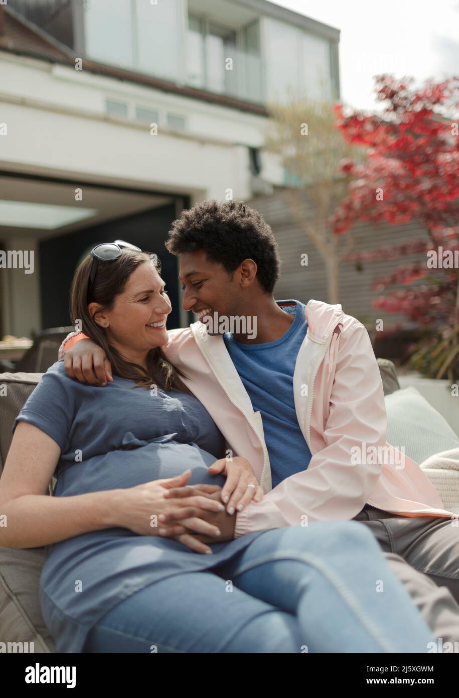 Glücklich liebevoll schwanger Paar auf der Terrasse Stockfoto