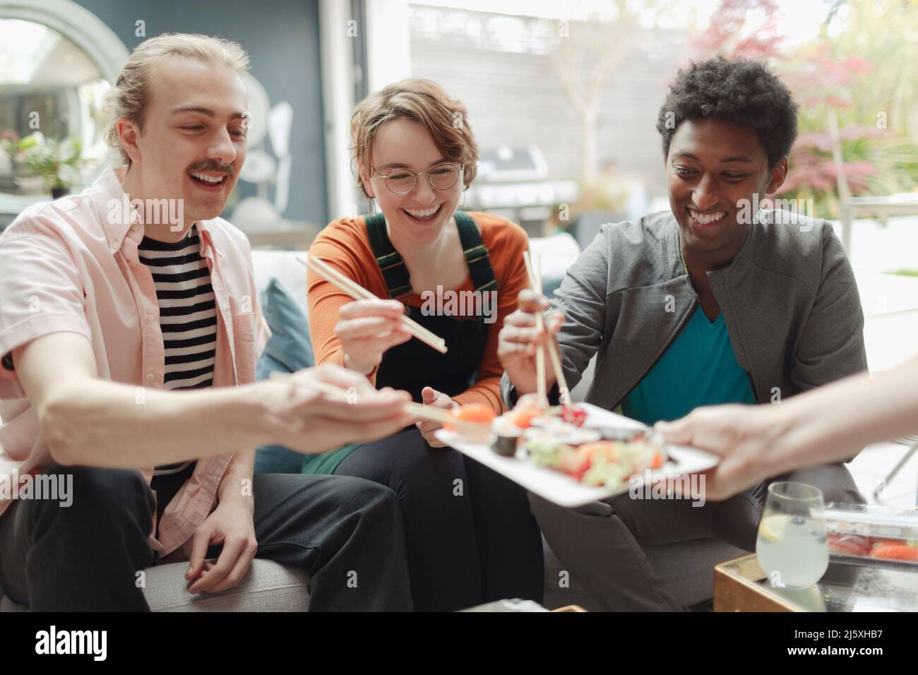 Glückliche Freunde teilen sich das Sushi-Mittagessen Stockfoto