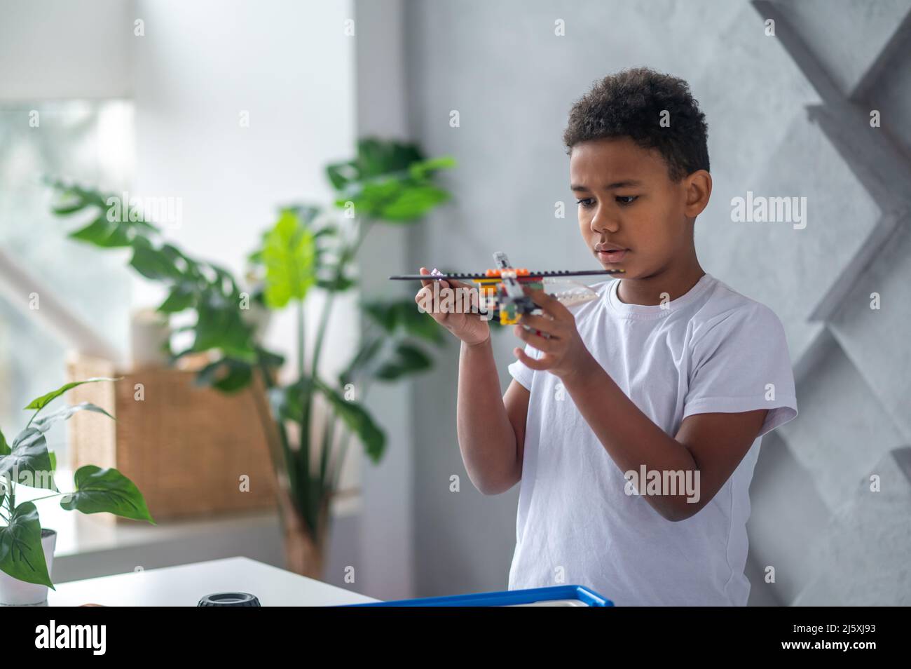 afroamerikanischer Teenager mit einem Spielzeug-Hubschrauber in den Händen Stockfoto