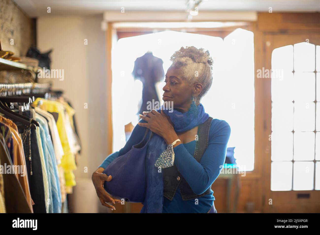 Ältere Frau, die in einer Bekleidungsboutique einkauft Stockfoto