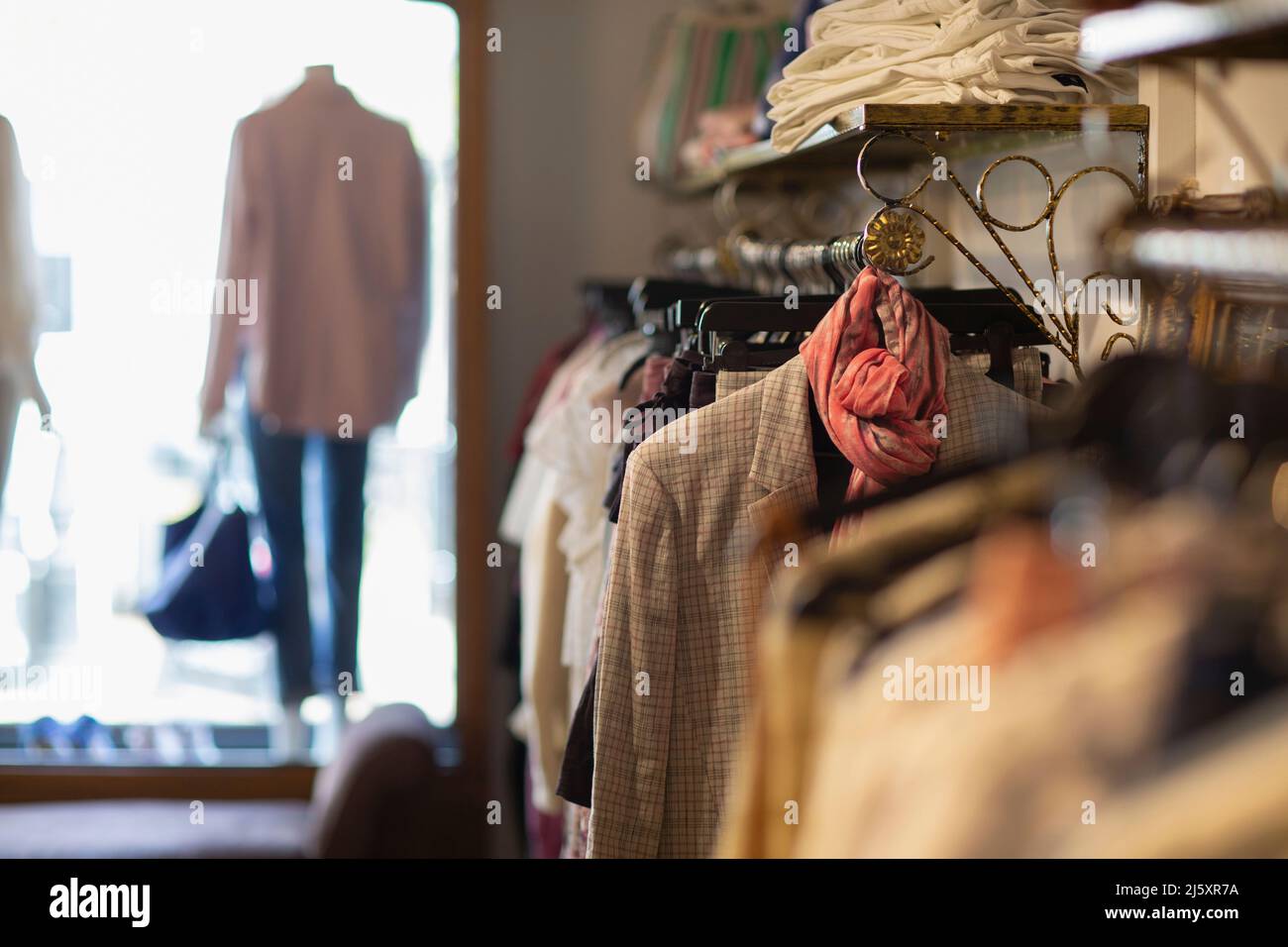 In der Boutique hängen Kleider an Regalen Stockfoto