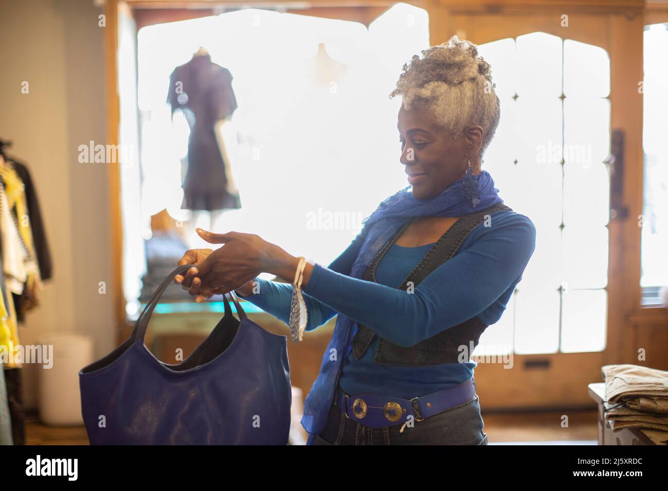 Ältere weibliche Shopper bei der Suche nach Handtasche in der Boutique Stockfoto