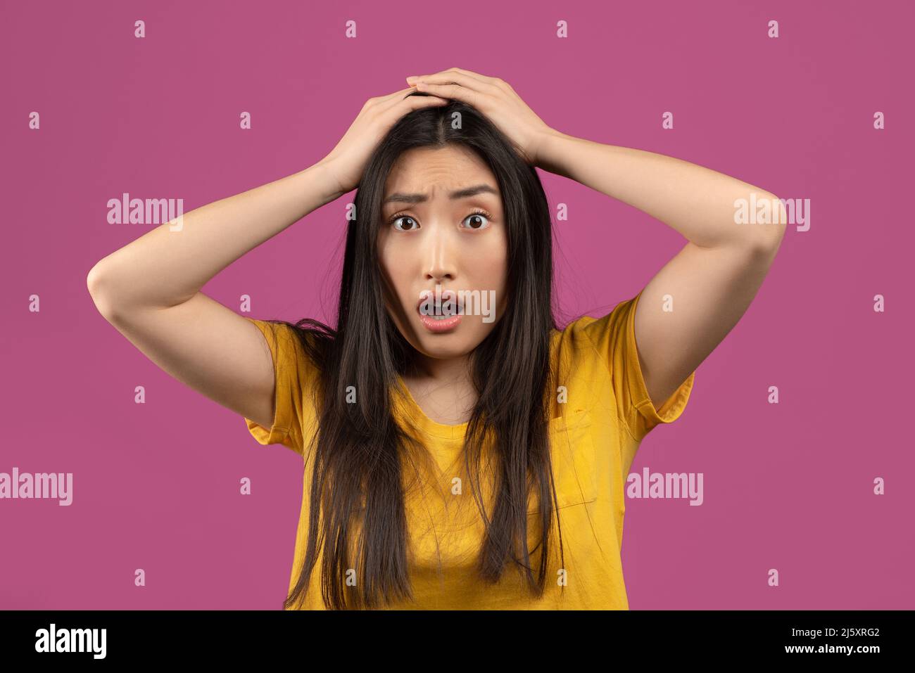 Unglaubliche Nachrichten. Schockierte asiatische Frau berührt ihren Kopf, kann nicht glauben, erstaunliche Angebot oder Verkauf, violetten Hintergrund Stockfoto