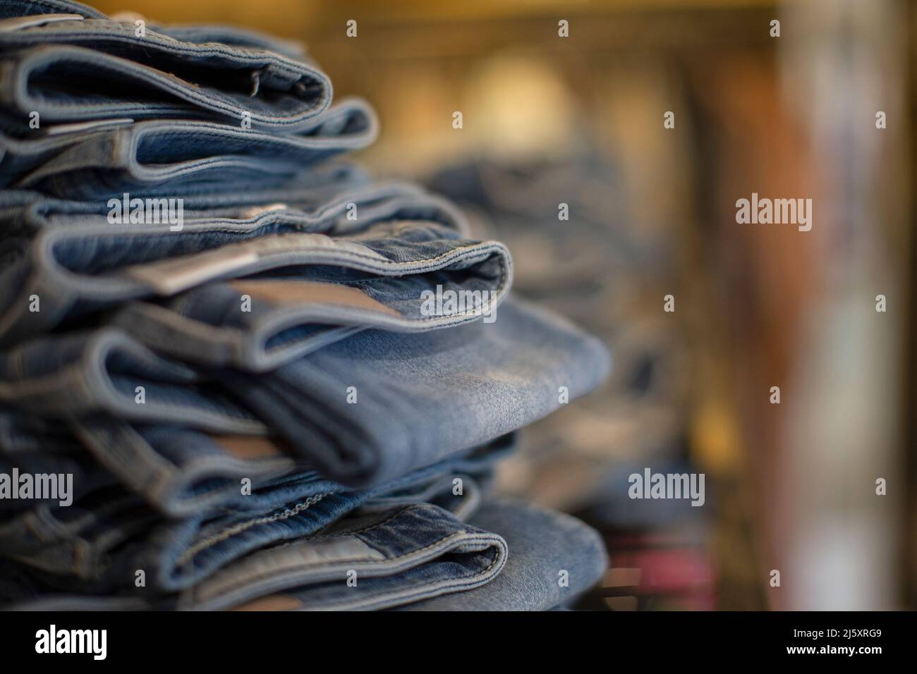 Im Geschäft gestapelte Denim-Jeans aus nächster Nähe Stockfoto