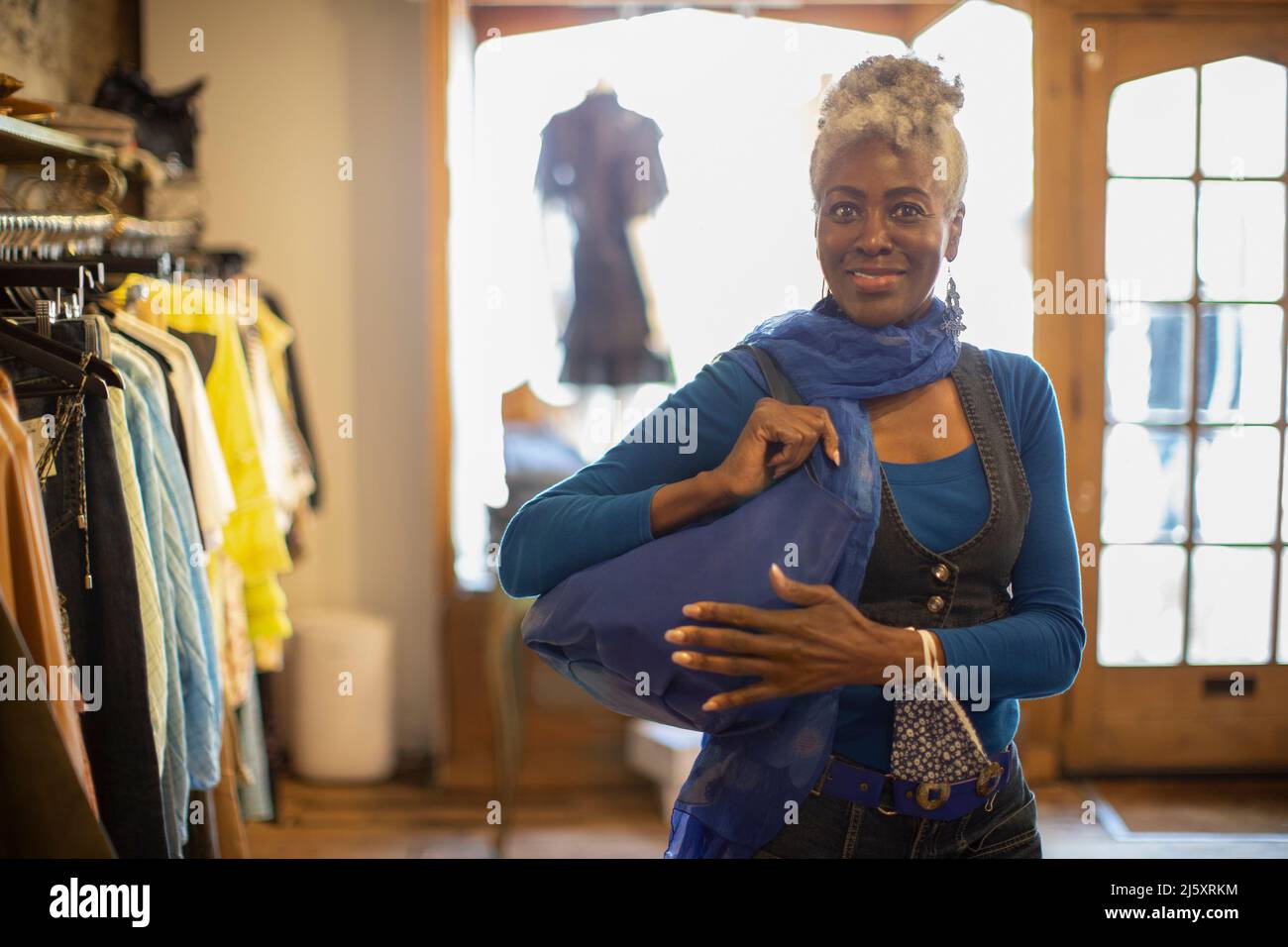 Portrait selbstbewusst weibliche Shopper mit blauer Handtasche im Geschäft Stockfoto