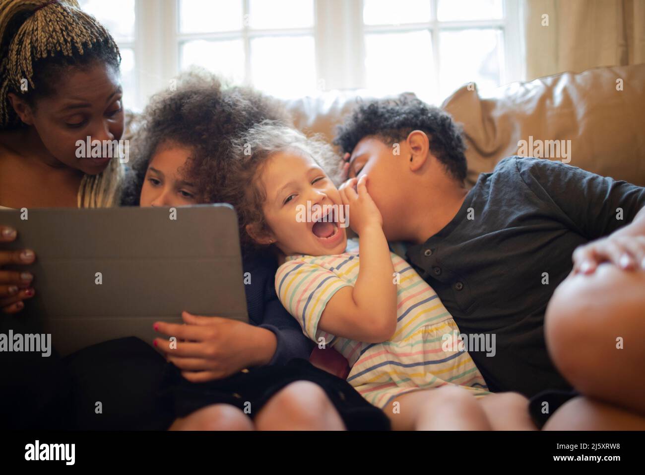 Mutter und Kinder mit digitalem Tablet auf dem Sofa Stockfoto