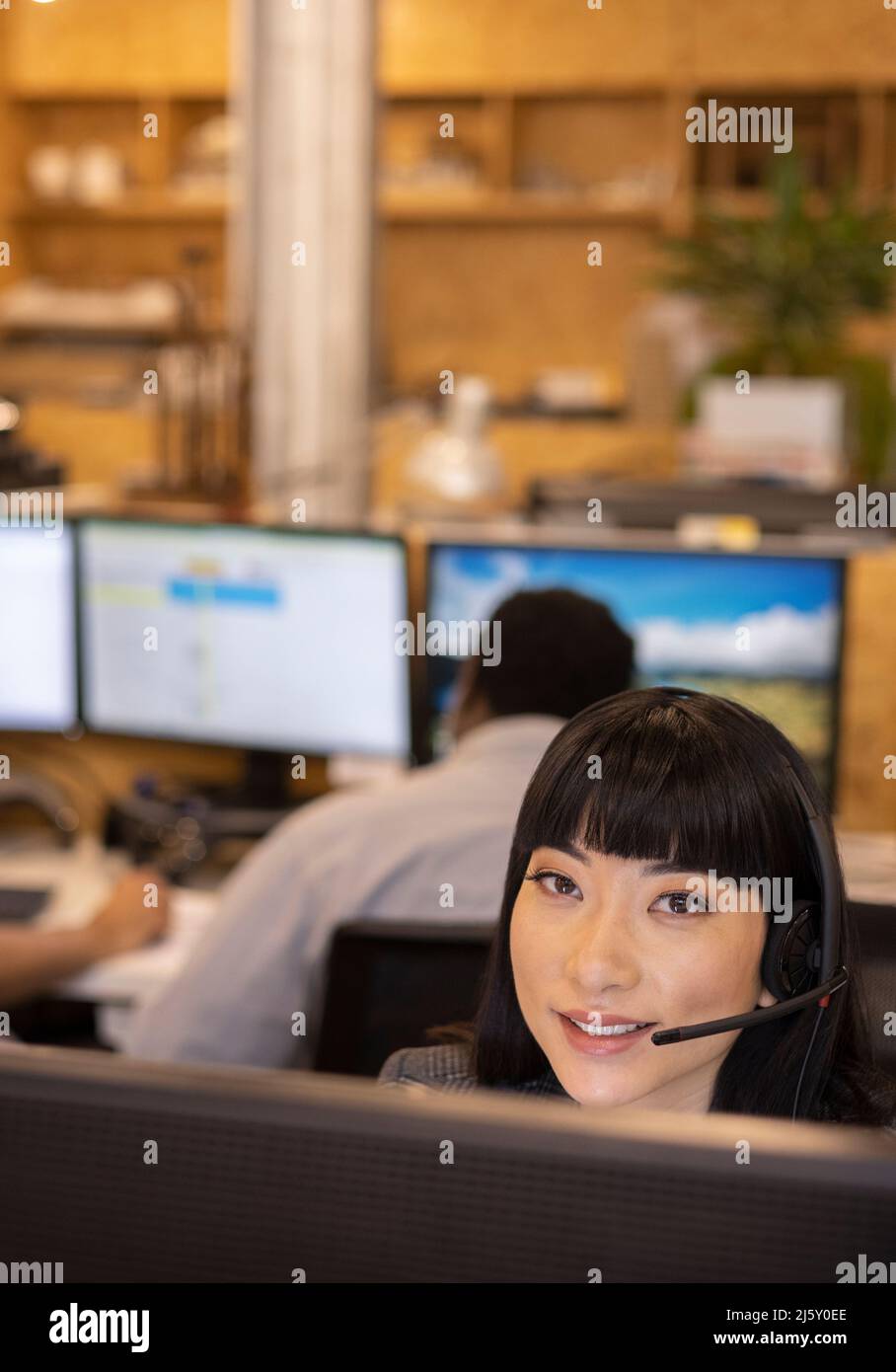 Portrait selbstbewusste Geschäftsfrau im Headset am Computer Stockfoto