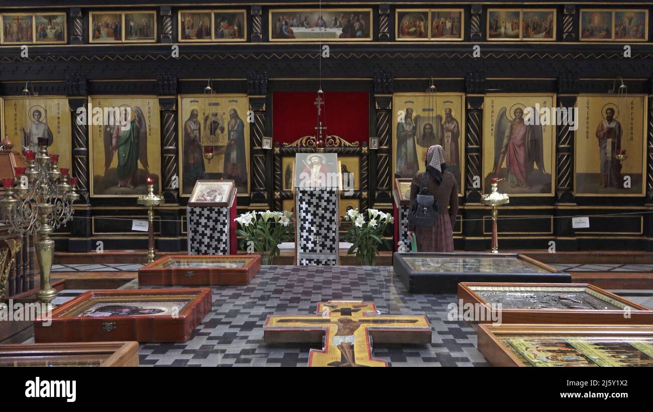 Ein orthodoxer Pilger aus dem Osten blickt auf religiöse Ikonen in der Kirche des heiligen Alexander Newski, die sich neben der Grabeskirche in der Altstadt am 20. April 2022 in Jerusalem, Israel, befindet. Der russische Präsident Wladimir Putin forderte kürzlich, dass Israel die Kirche und ihren als „Alexanderhof“ bekannten Komplex gemäß einer Vereinbarung der vorherigen israelischen Regierung der russischen Souveränität übergibt. Stockfoto