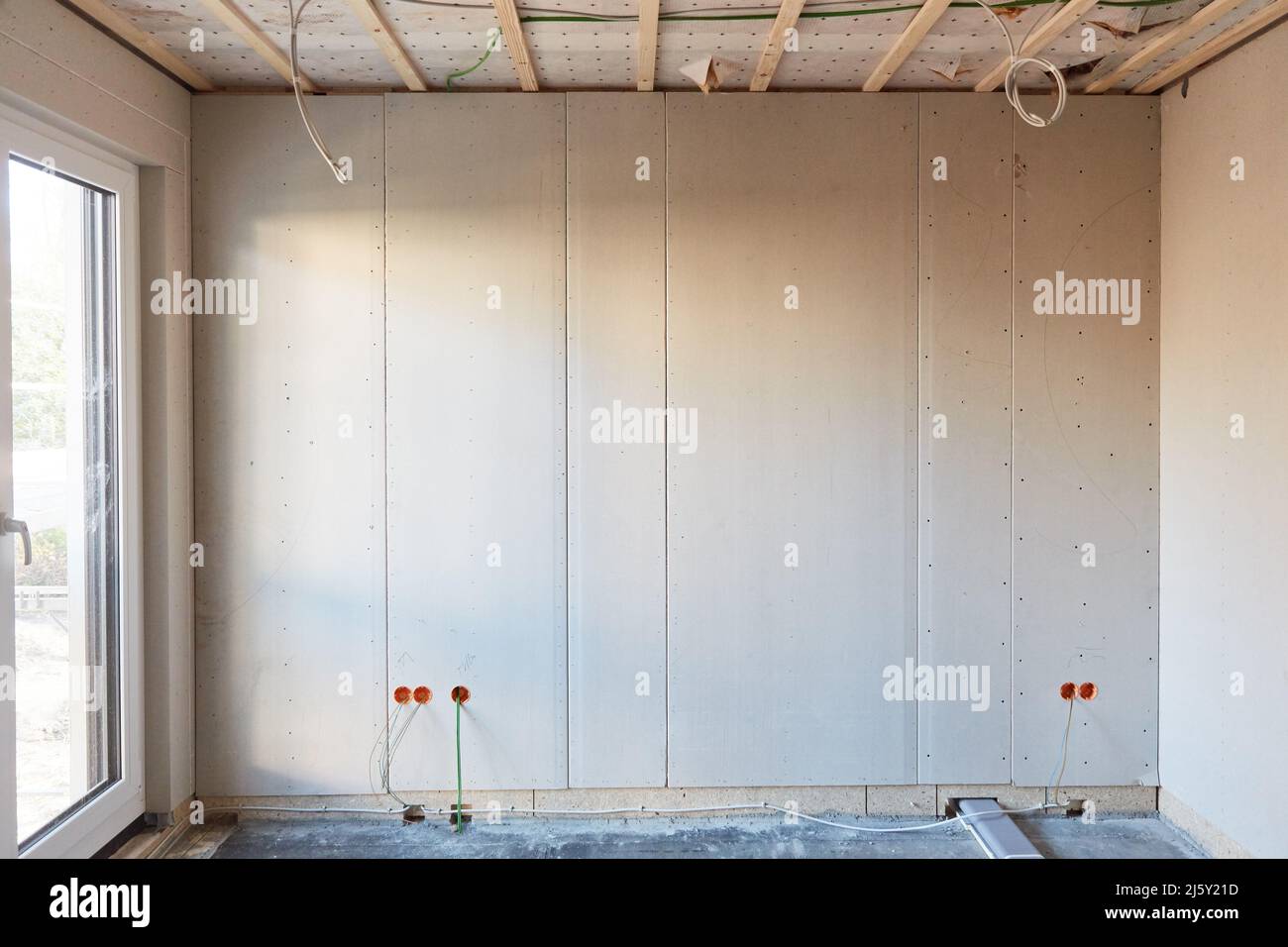 Leerer Raum mit Fenster auf der Baustelle beim Hausbau mit Trockenbau Stockfoto