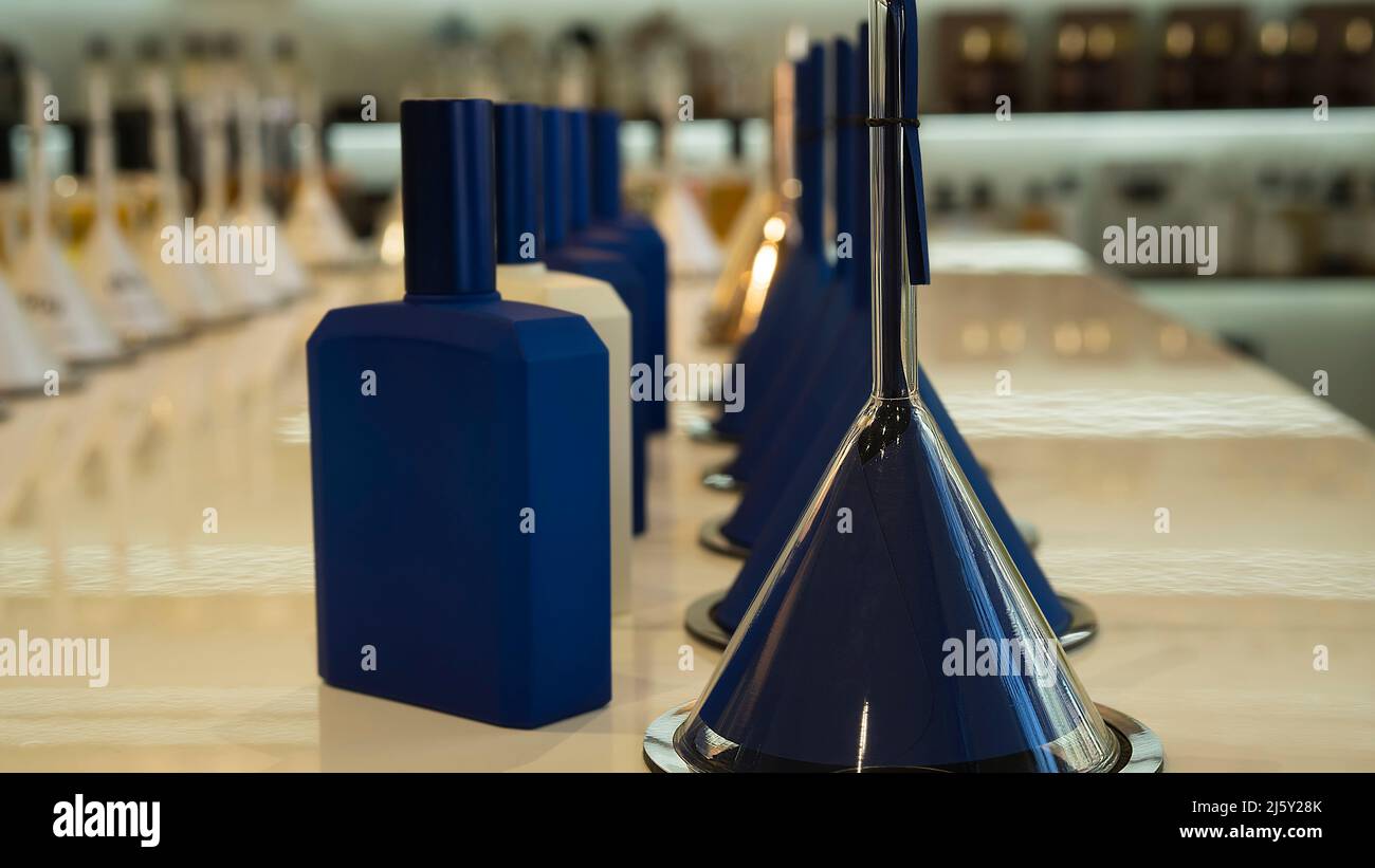 Parfümflaschen und Trichter mit Duft auf der Theke in einem Luxusladen. Kosmetische Produkte Ausstellung Verkauf Stockfoto