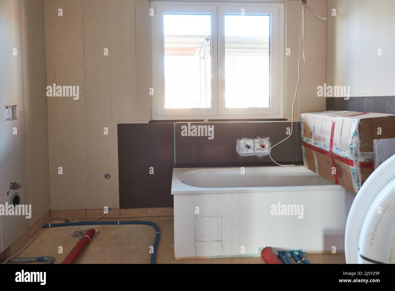 Badezimmer mit Badewanne als Baustelle mit Baustoffen beim Bau eines Hauses Stockfoto