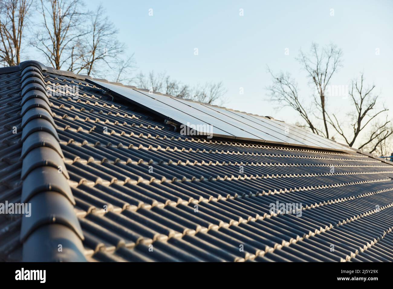 Moderne Solaranlage auf dem Dach eines Hauses gegen einen blauen Himmel Stockfoto