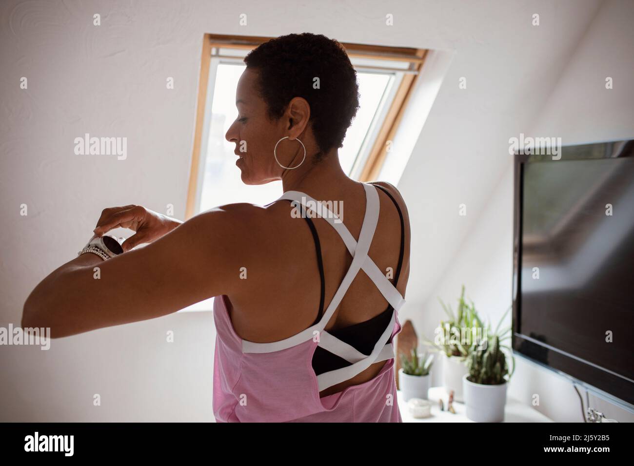 Ältere Frau im Tank Top Überprüfung intelligente Uhr Stockfoto