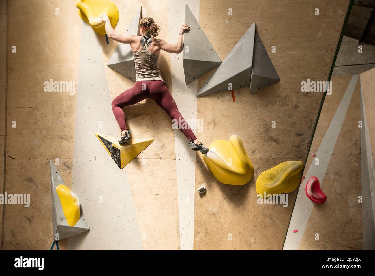 Junge, starke Frau an der Kletterwand Stockfoto