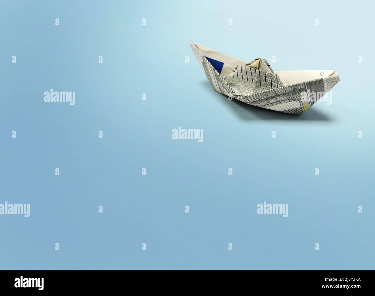 Origami-Versand von 5 Euro Banknote auf blauem Hintergrund Stockfoto