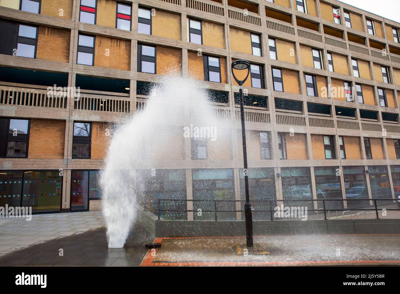 Ein platztes Wasserrohr. Hyde Park Flats, von denen einige noch renoviert werden, Sheffield. Stockfoto