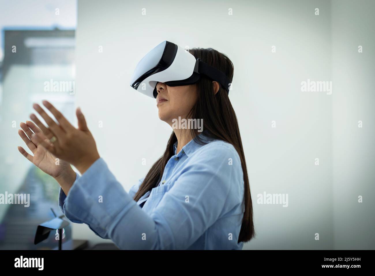 Frau gestikelt, mit VR-Headset Stockfoto