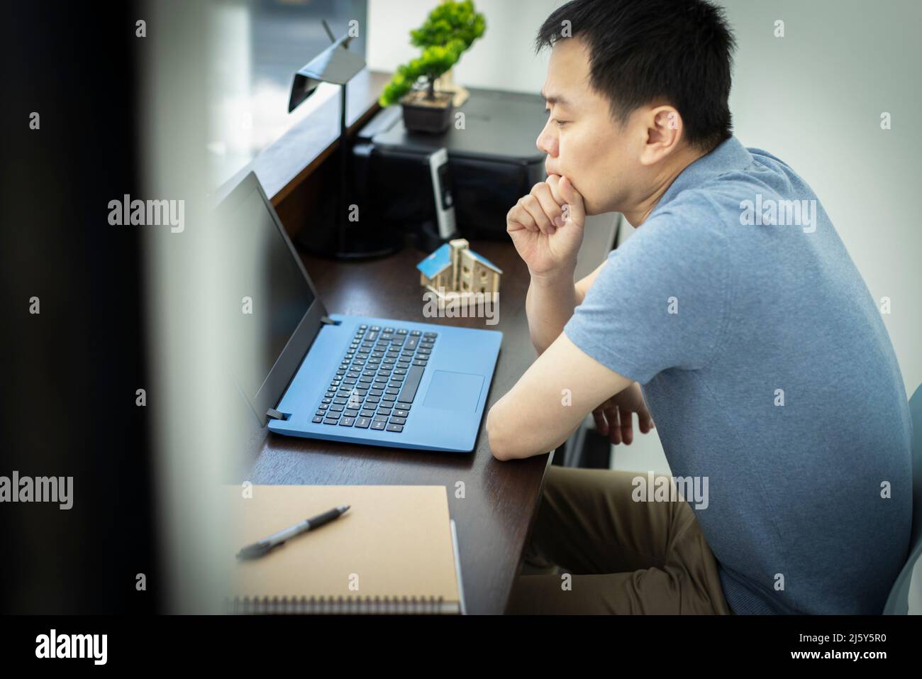 Durchdachter männlicher Ingenieur, der im Büro am Laptop arbeitet Stockfoto