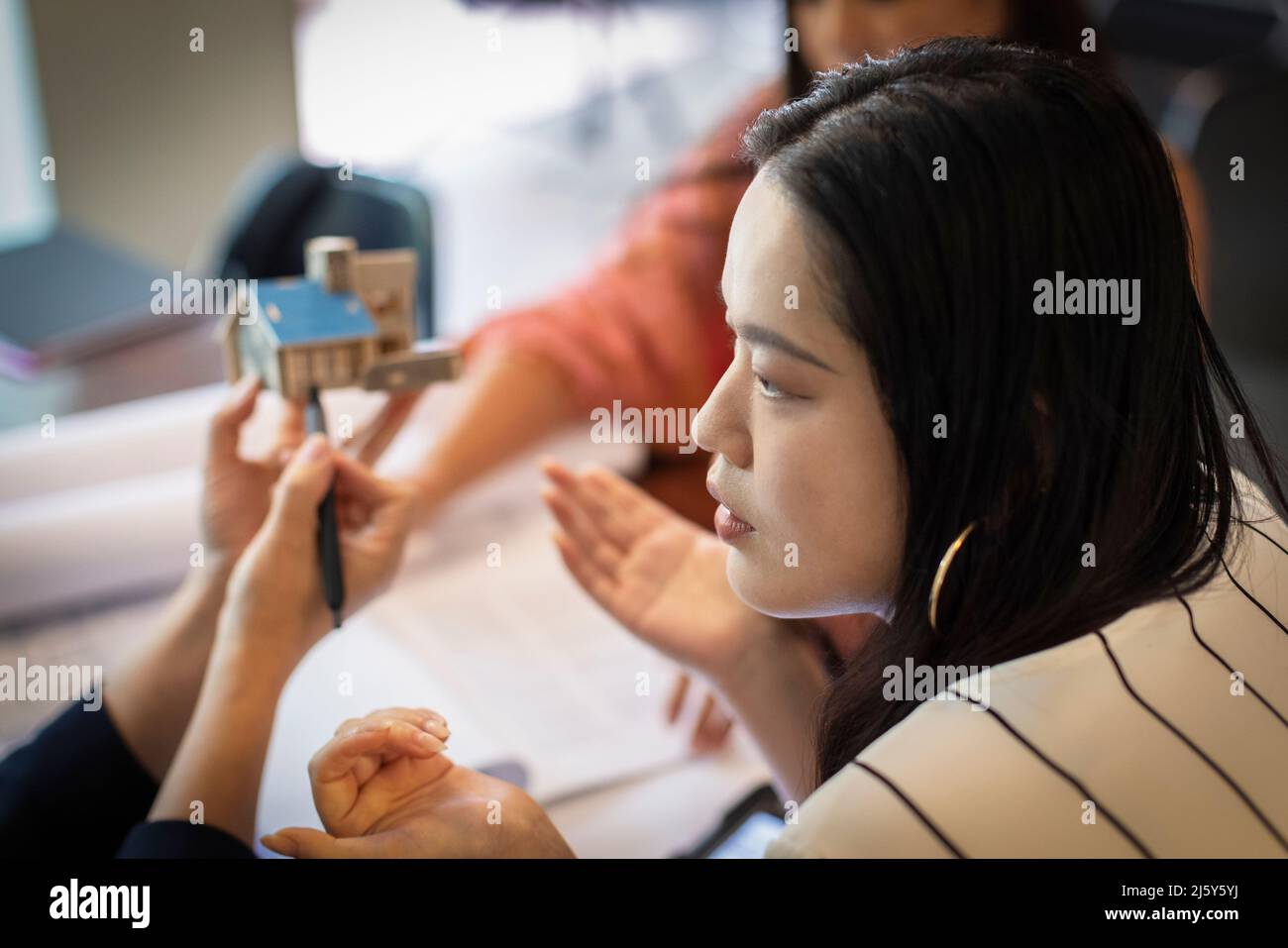 Architektin diskutiert mit Kollegen über das Hausmodell Stockfoto