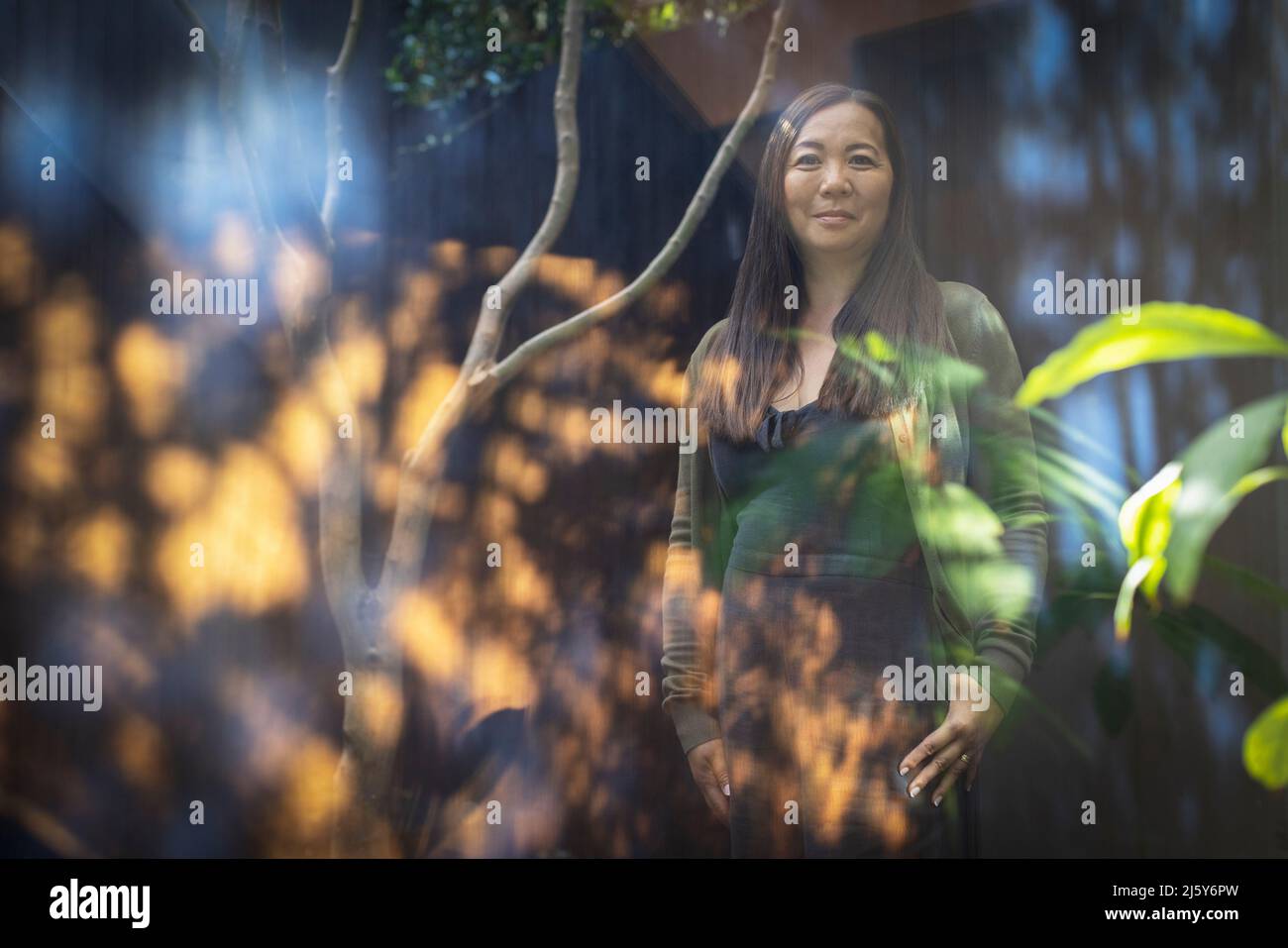 Portrait selbstbewusste Frau im sonnigen Innenhof Stockfoto