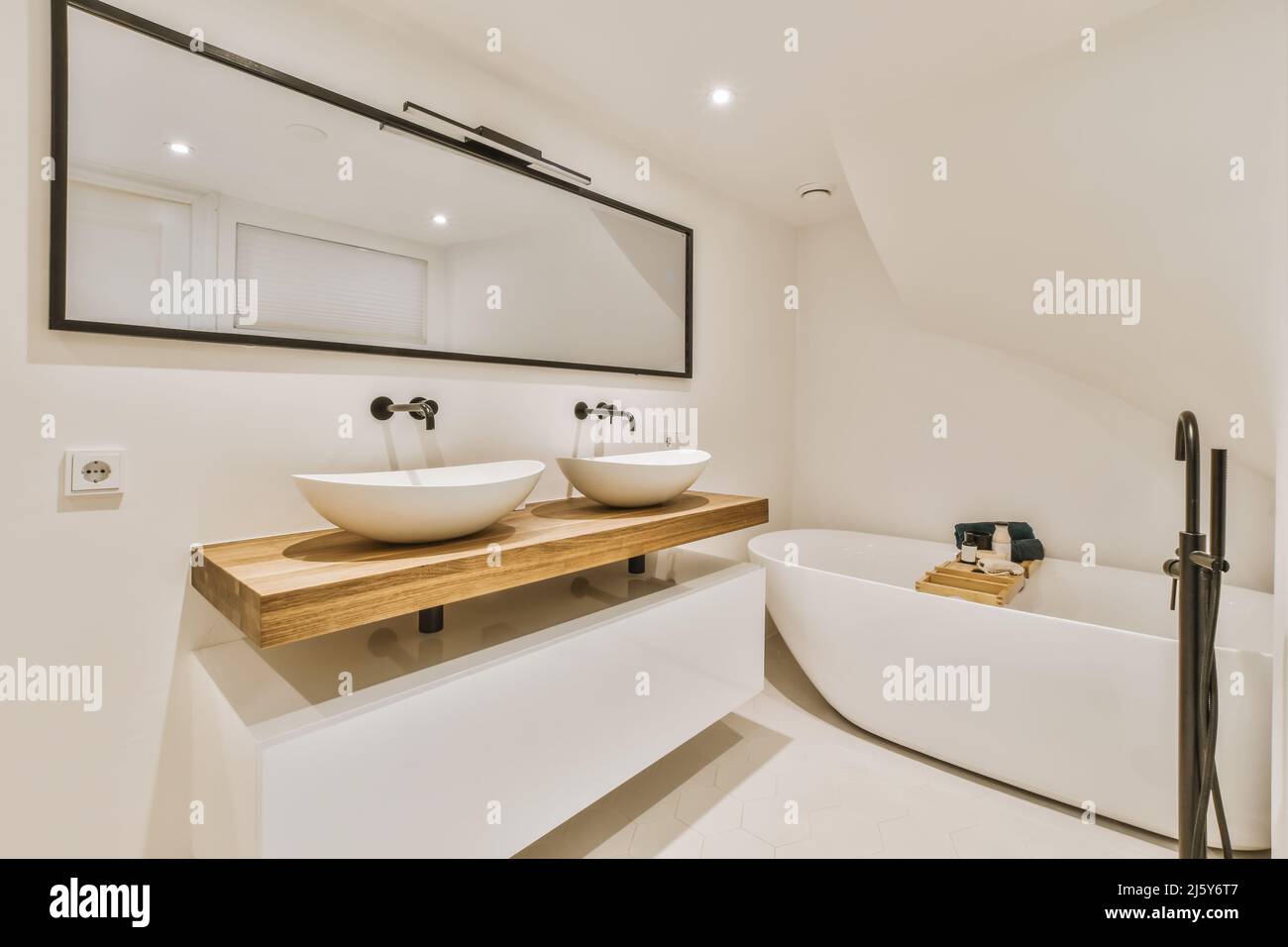 Weiße Waschbecken auf Holzfläche an der Wand mit Spiegel im hellen  Badezimmer mit Tablett auf Keramik-Badewanne in der Wohnung platziert  Stockfotografie - Alamy