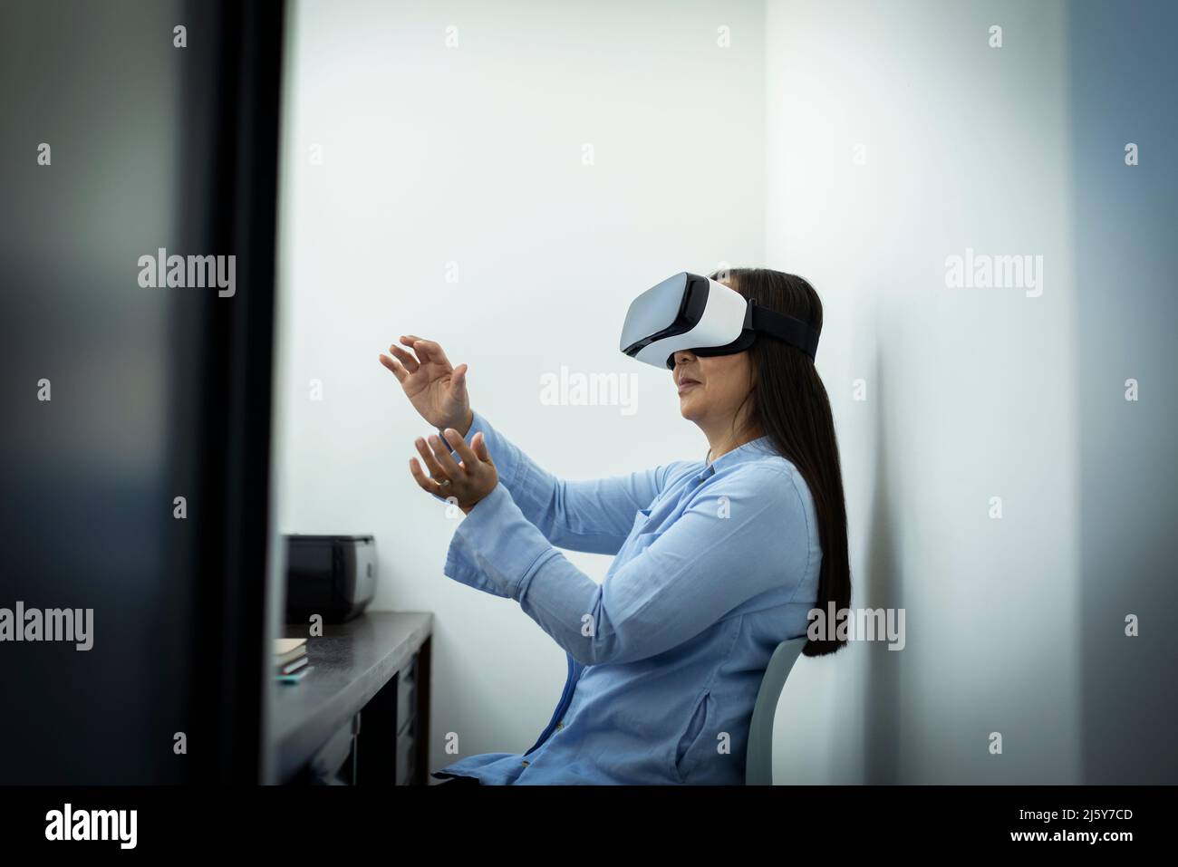 Geschäftsfrau, die im Büro ein VR-Headset verwendet Stockfoto