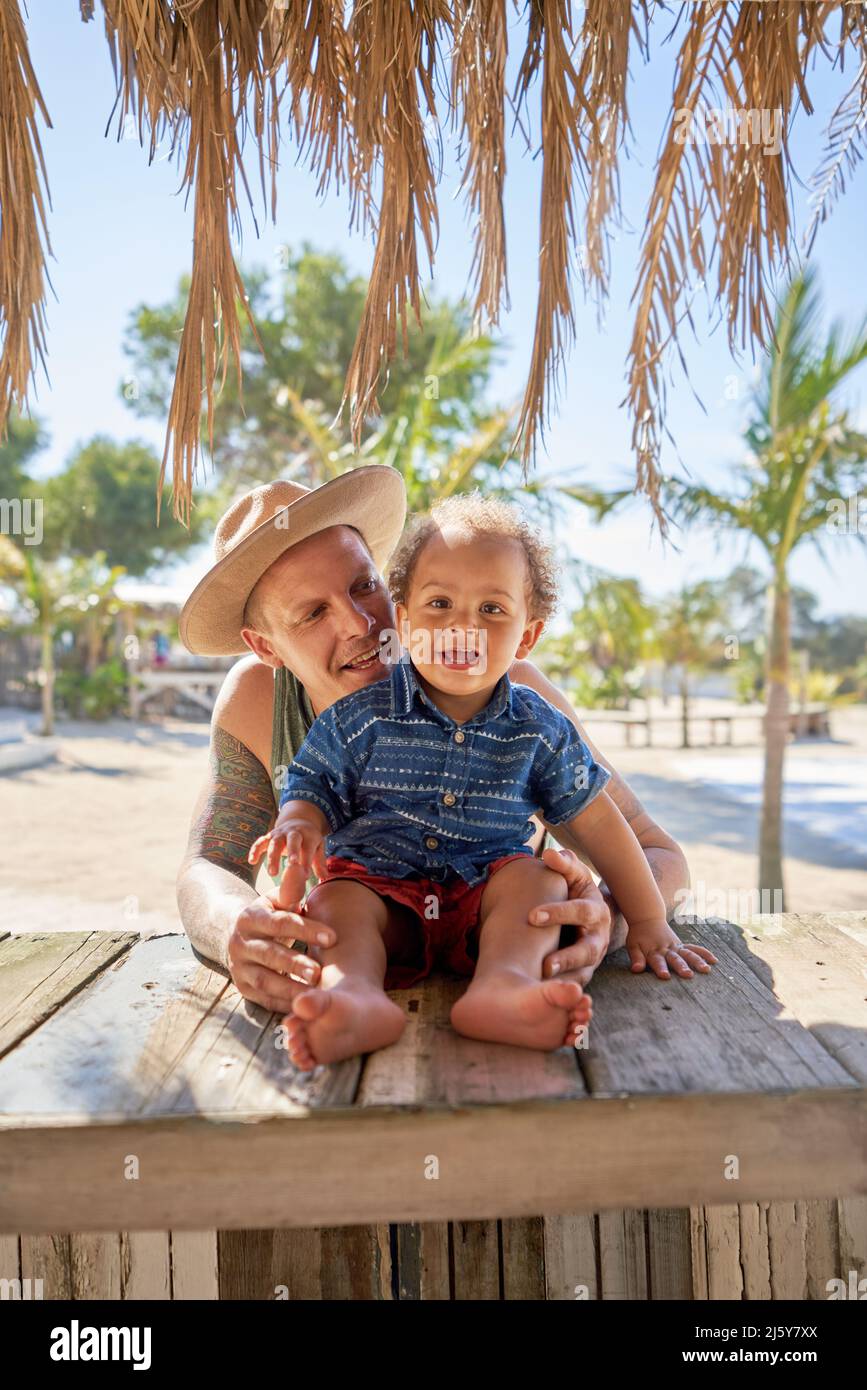 Portrait glücklicher Vater und Kleinkind Sohn in der Strandhütte Stockfoto