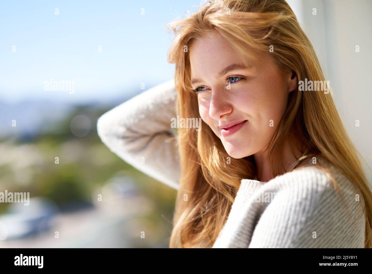Portrait schöne junge Frau mit roten Haaren auf sonnigen Terrasse Stockfoto