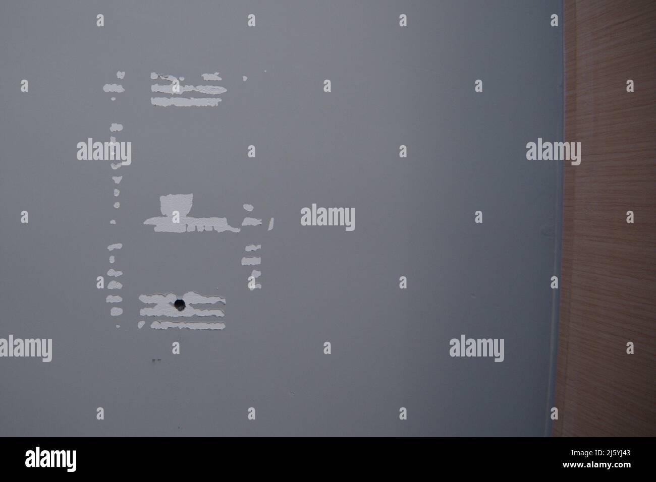 Beschriftungszeichen und Bohrloch an der Wand - Verschleiß Stockfoto