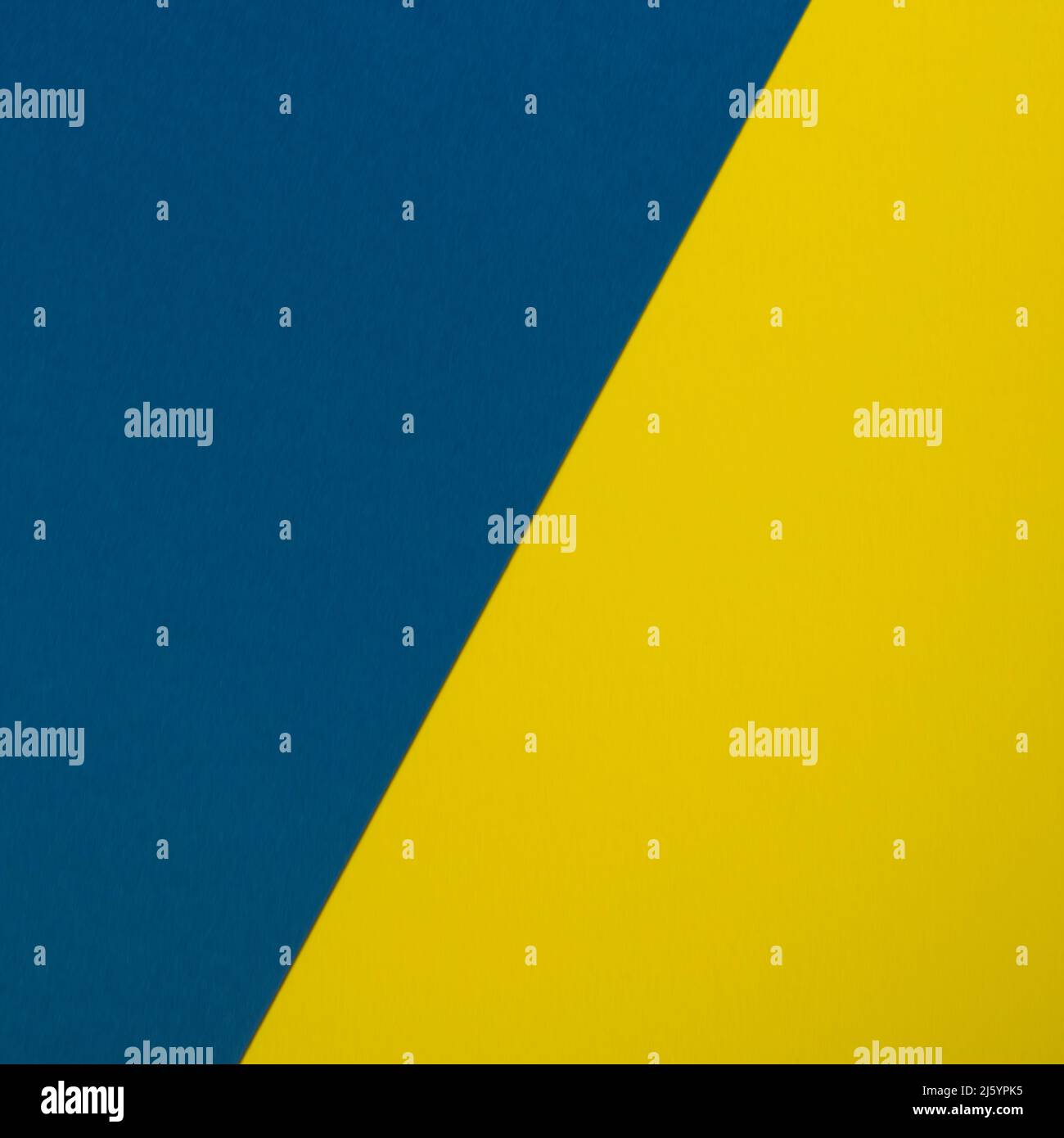Zwei Blätter aus gelbem und blauem Papier überlappend als Hintergrund angeordnet Stockfoto